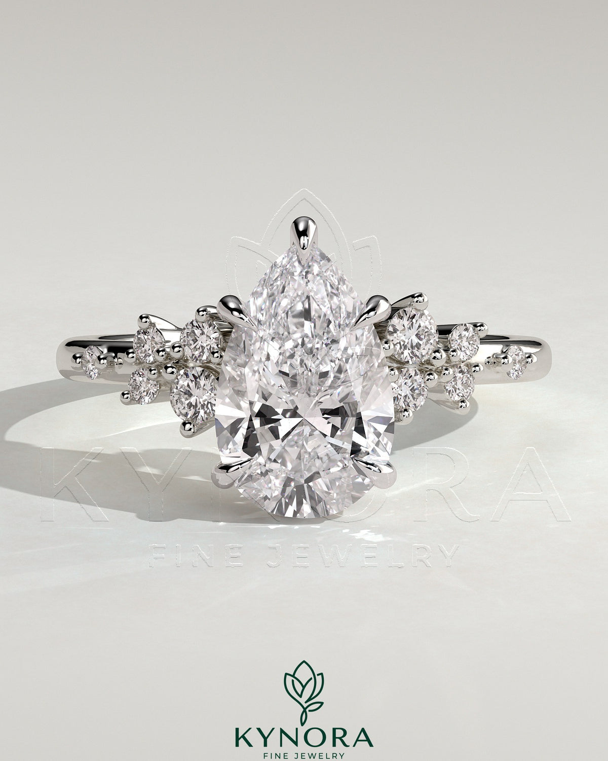 Kynora CJ 2ct pear-shaped diamond solitaire engagement ring with clustered round shoulder stones, crafted in sterling silver.