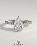Kynora CJ 2ct pear-shaped diamond solitaire engagement ring with hidden halo and pave band, elegant jewelry piece.
