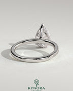 Kynora CJ 2ct pear-shaped diamond solitaire engagement ring with hidden halo and pave band, elegant and sparkling jewelry piece.