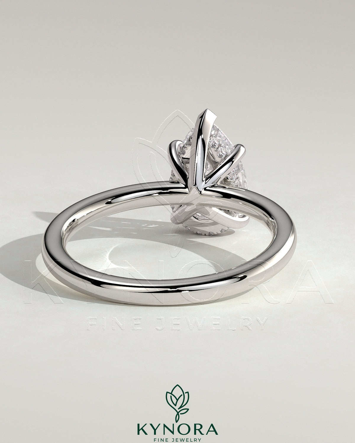 Kynora CJ 2-carat pear-shaped diamond solitaire engagement ring with hidden halo design, featuring a sleek gold band.