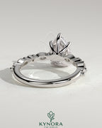 Kynora CJ 2ct pear-shaped diamond solitaire engagement ring with marquise and round accent stones in a elegant setting.