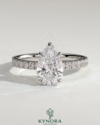 Kynora CJ 2ct pear-shaped diamond solitaire engagement ring with pave band in sterling silver, showcasing elegant jewelry design.