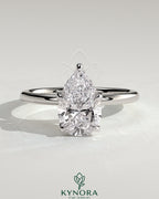 Kynora CJ 2ct pear-shaped diamond solitaire engagement ring with petal gallery and accented tiara detail, silver band.