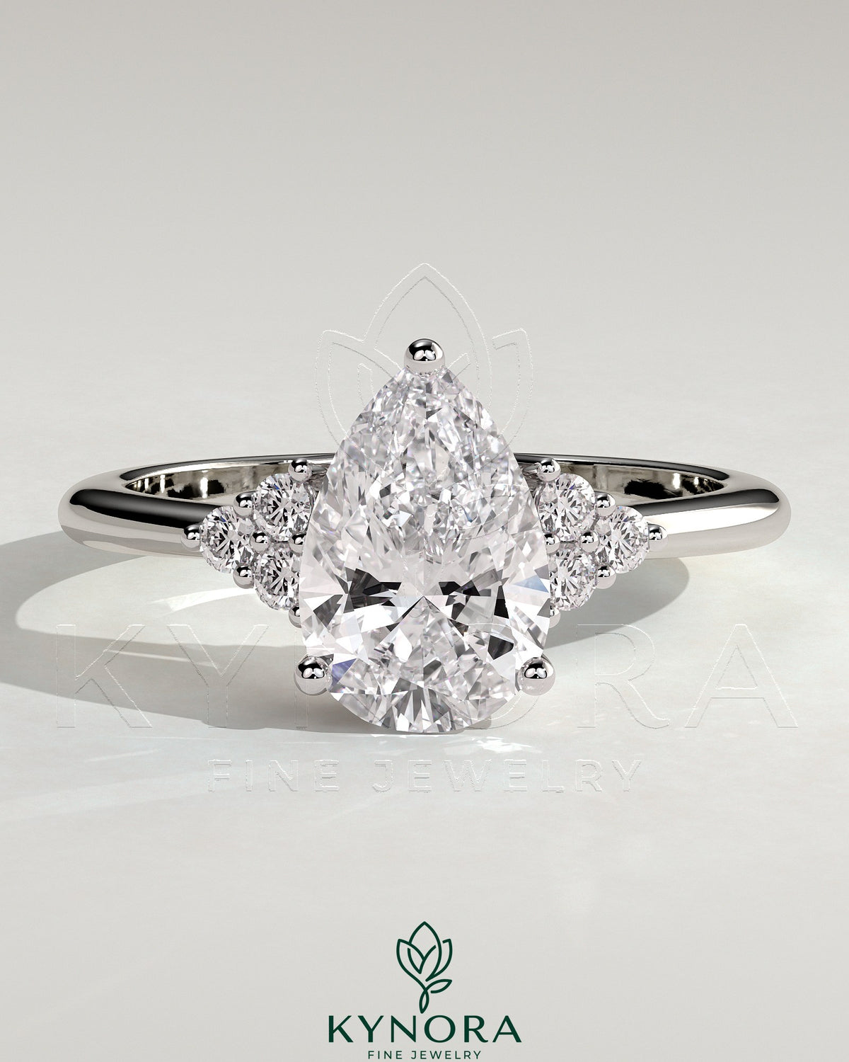 Kynora CJ 2ct pear-shaped diamond solitaire engagement ring with round shoulder stones in a sleek platinum setting.