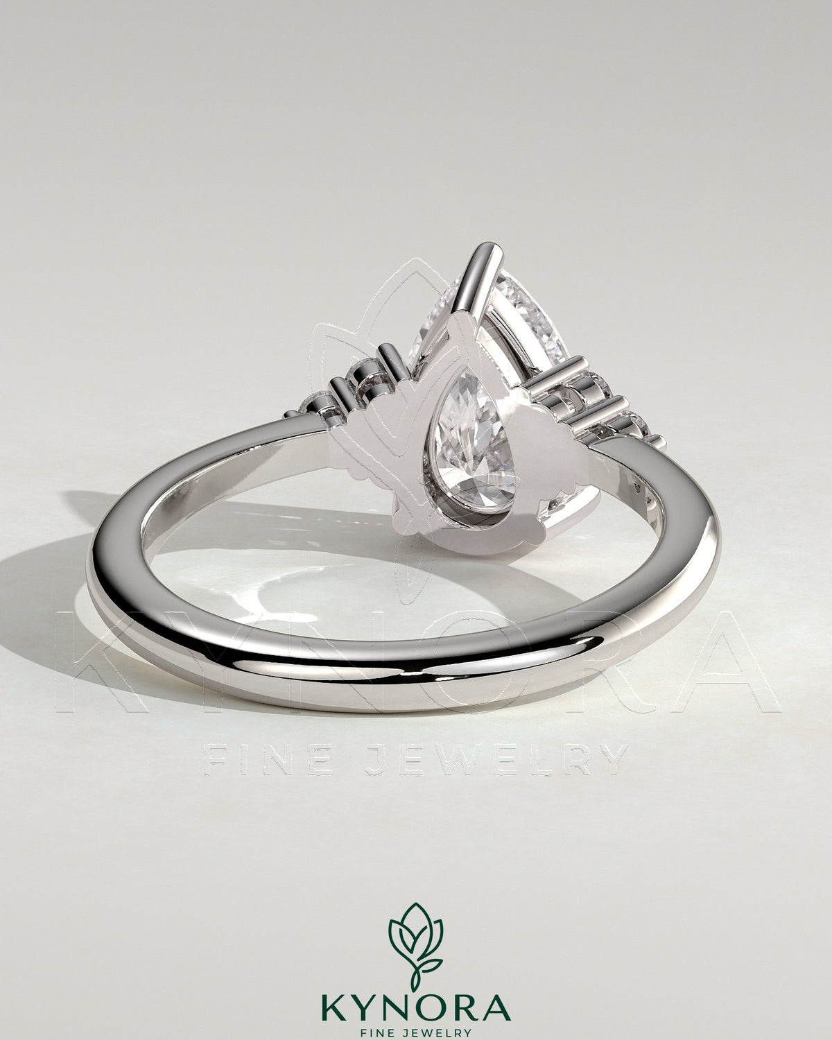 Kynora CJ 2ct pear-shaped diamond solitaire engagement ring with round shoulder stones in a sleek platinum setting.