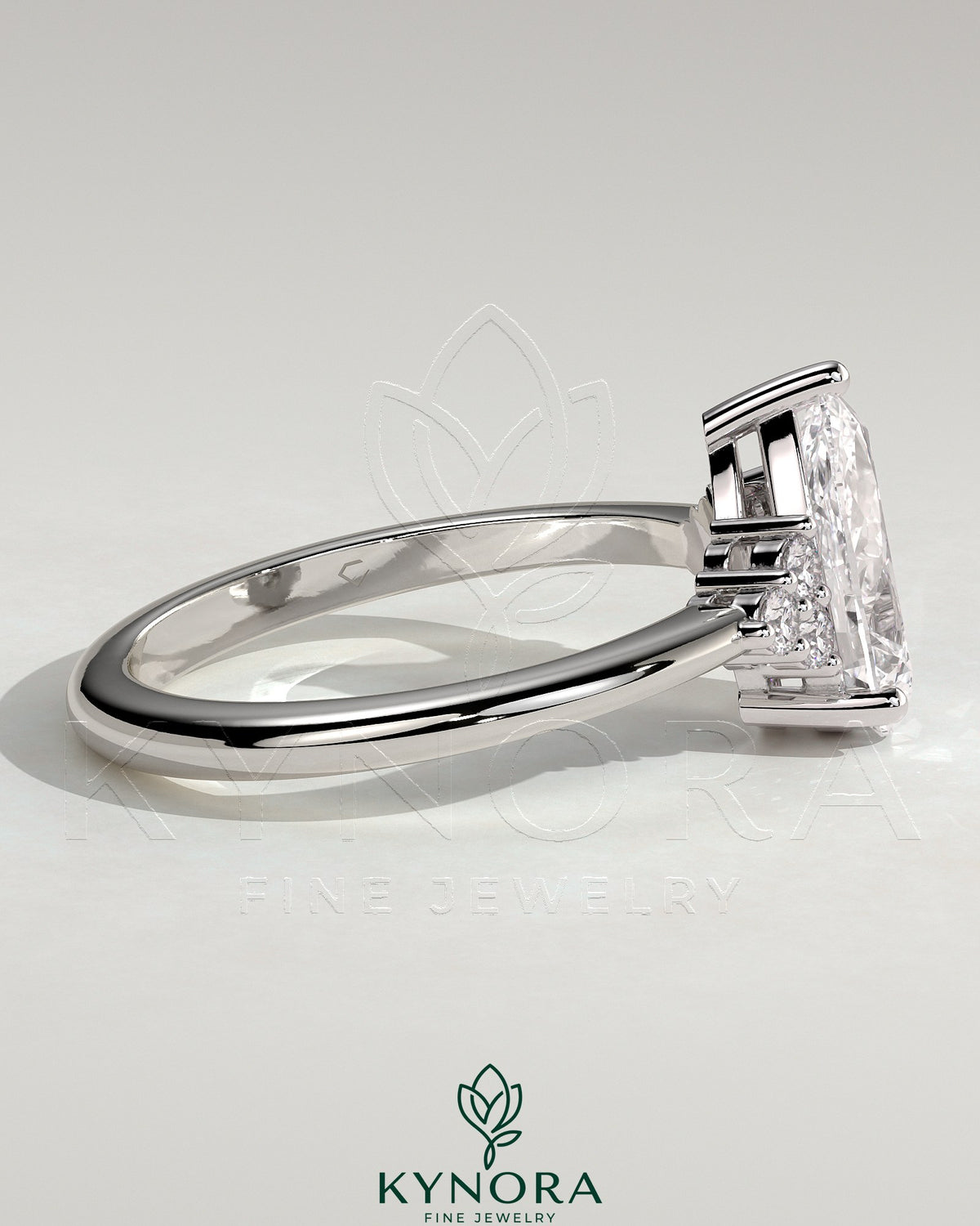 Kynora CJ 2ct Pear Claw Solitaire engagement ring with round shoulder stones and detailed band design.
