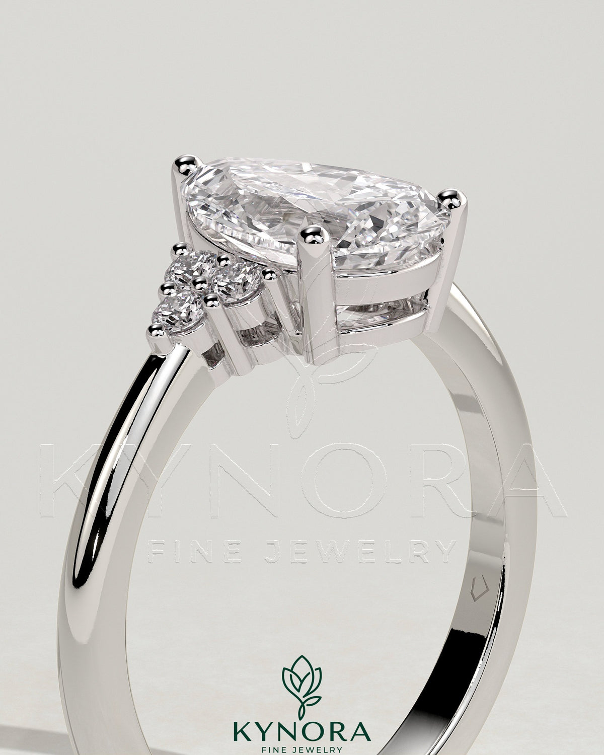Kynora CJ 2ct pear-shaped diamond solitaire engagement ring with round shoulder accent stones, elegant and sparkling jewelry piece.