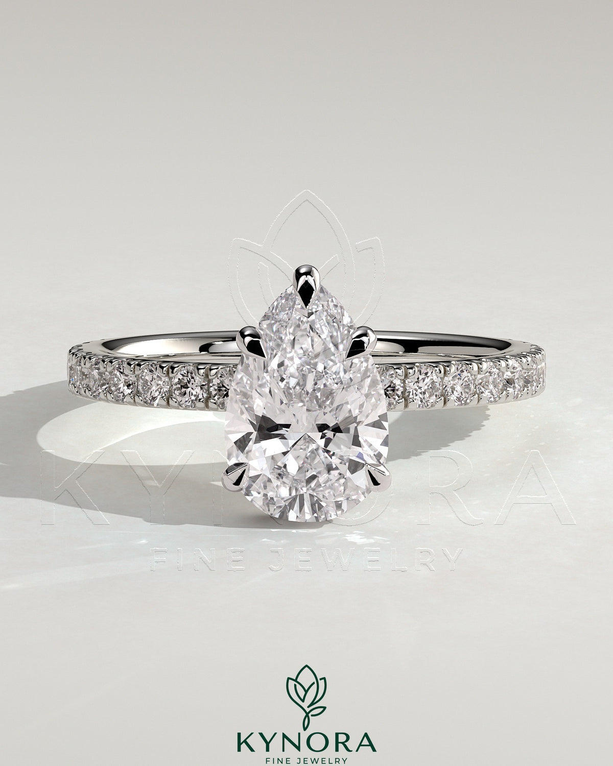 Kynora CJ 2ct pear-shaped solitaire engagement ring with wrap-around hidden halo and pave band, five-prong setting. Main image