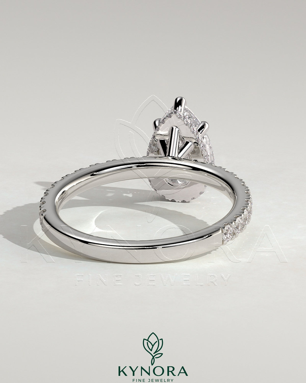 Kynora CJ 2ct pear-shaped diamond solitaire engagement ring with wrap-around hidden halo and pave band, five-prong setting.