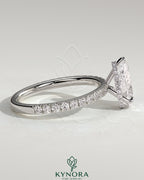 Kynora CJ 2ct pear-shaped diamond solitaire engagement ring with hidden halo and pave band, three-prong setting.