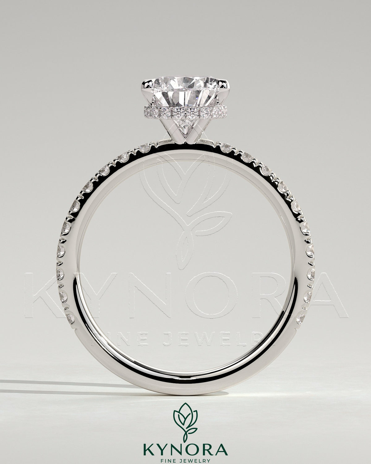 Kynora CJ 2ct pear-shaped diamond solitaire engagement ring with wrap-around hidden halo and pave band, three-prong setting