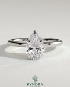 2-carat pear-shaped diamond solitaire engagement ring with wrap-around hidden halo by Kynora CJ, showcasing elegant jewelry design.