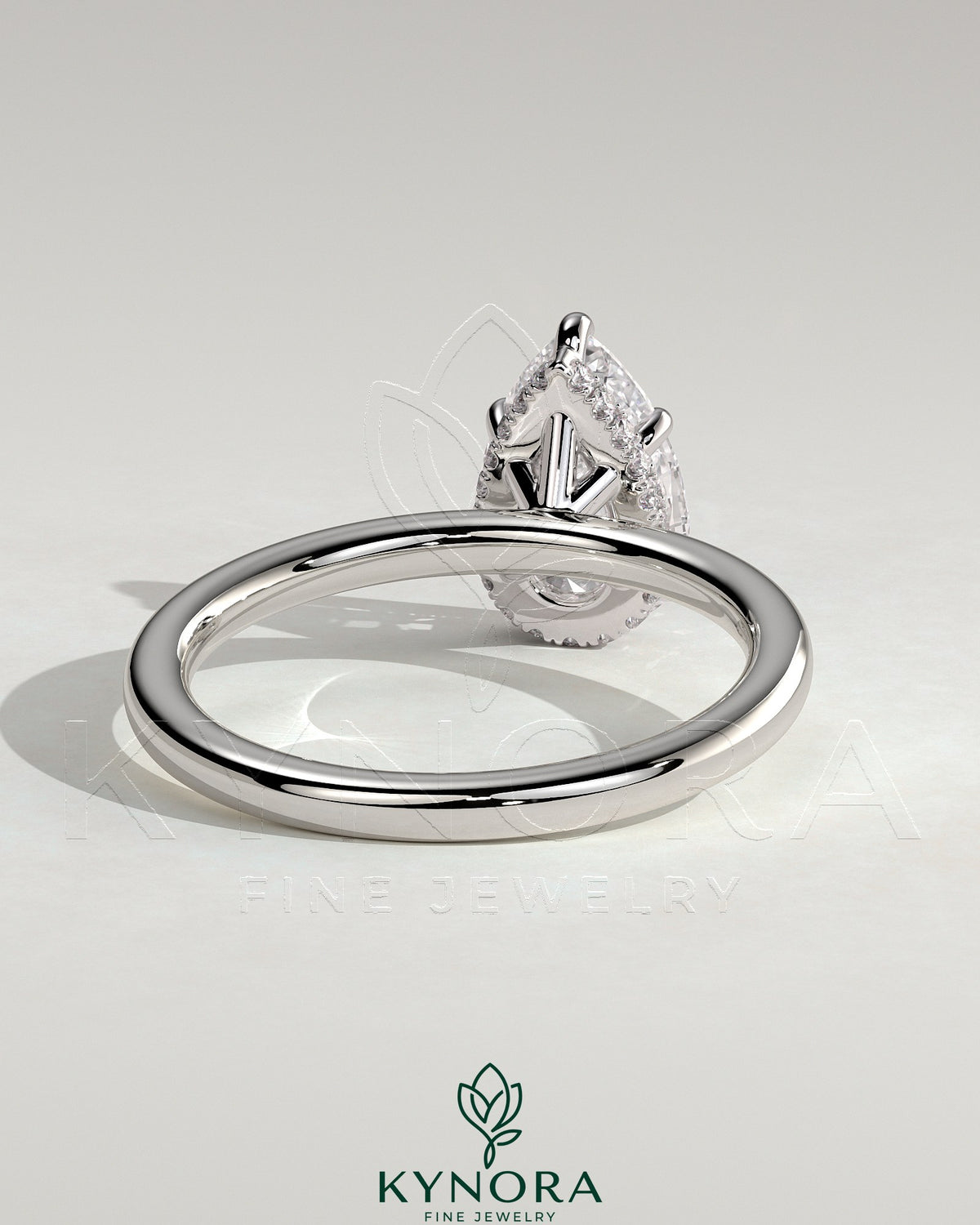 Kynora CJ 2ct pear-shaped diamond solitaire engagement ring with a wrap-around hidden halo design, crafted in elegant jewelry style.