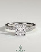 Kynora CJ 2ct princess claw solitaire engagement ring with wrap-around hidden halo and pave band, showcasing sparkling diamond details.
