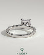 Kynora CJ 2ct princess cut solitaire engagement ring with wrap-around hidden halo and pave band, showcasing sparkling diamond details.