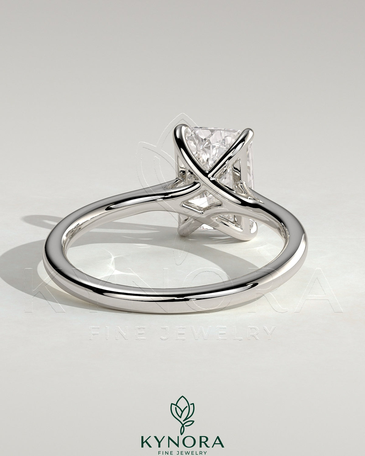 Kynora CJ 2ct radiant claw solitaire engagement ring with cathedral low setting and open trellis gallery in silver-tone metal.