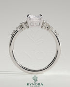 Kynora CJ 2ct radiant claw solitaire engagement ring with clustered round shoulder stones, showcasing elegant jewelry design.