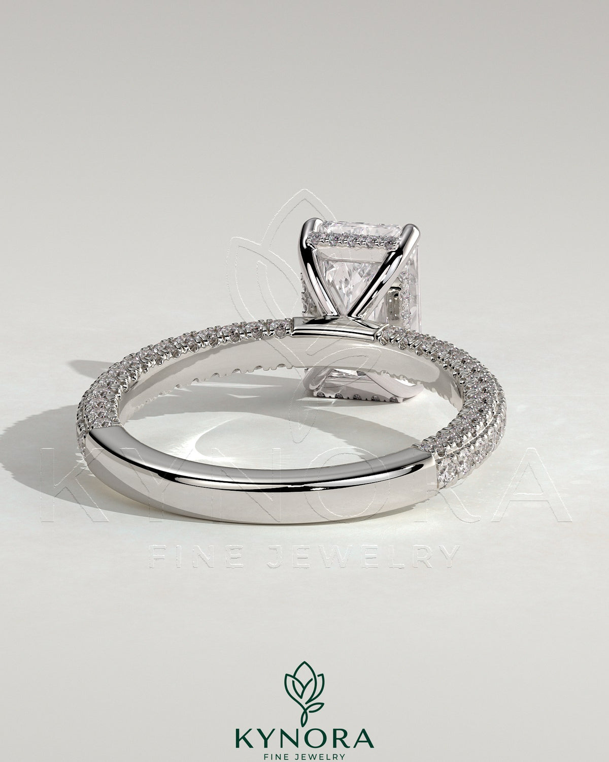 Kynora CJ 2ct radiant claw solitaire engagement ring with hidden halo and triple pave band, showcasing sparkling diamond design.