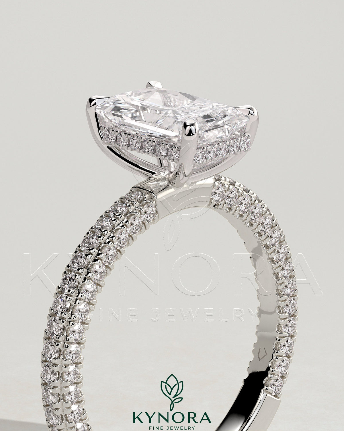 Kynora CJ 2ct radiant diamond solitaire engagement ring with hidden halo and triple pave band, featuring intricate metalwork.
