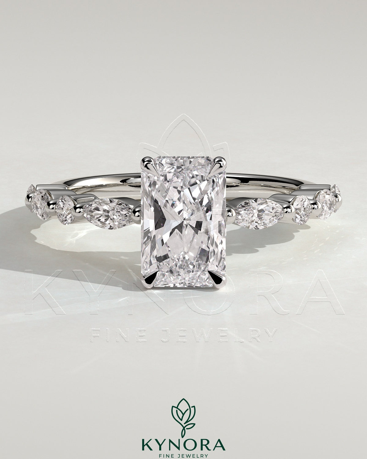Kynora CJ 2ct radiant claw solitaire engagement ring with marquise and round accent stones, featuring a wrap-around hidden halo design.