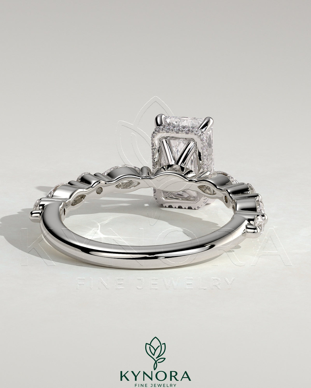 Kynora CJ 2ct radiant claw solitaire engagement ring with marquise and round accent stones, featuring a hidden halo design.