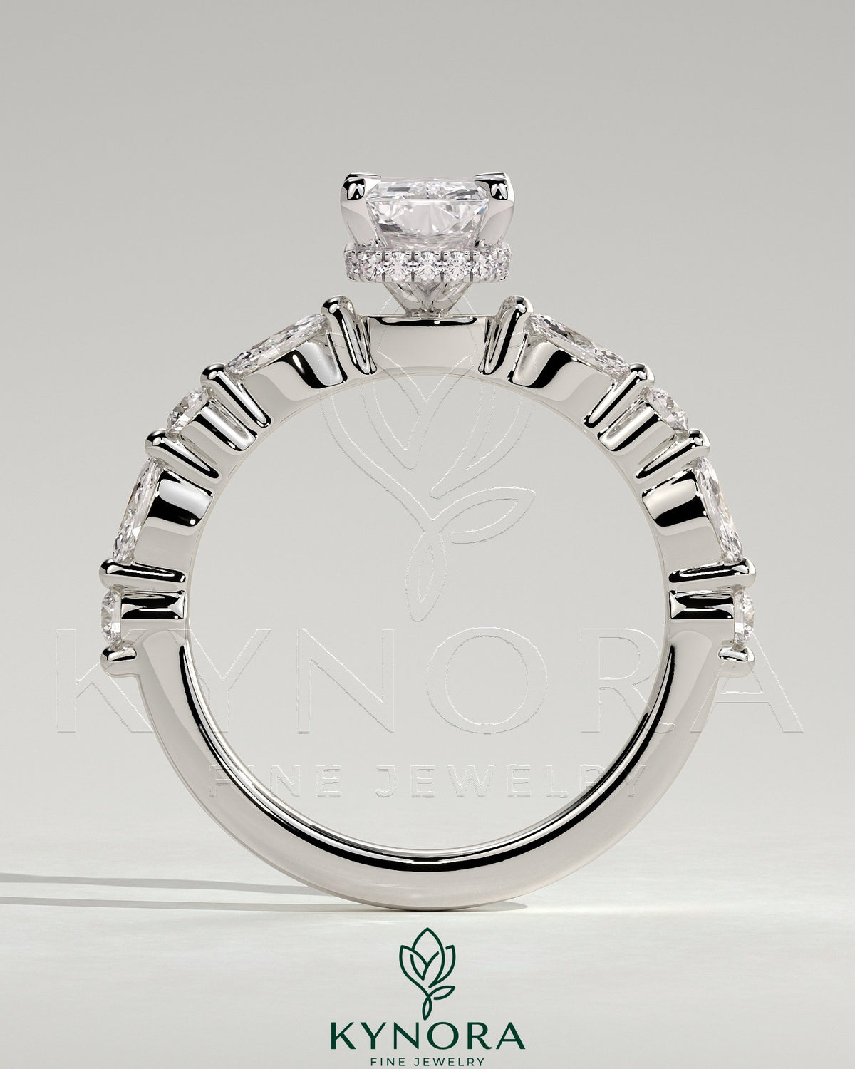 Kynora CJ 2ct radiant claw solitaire engagement ring with marquise and round accent stones, and a wrap-around hidden halo design.