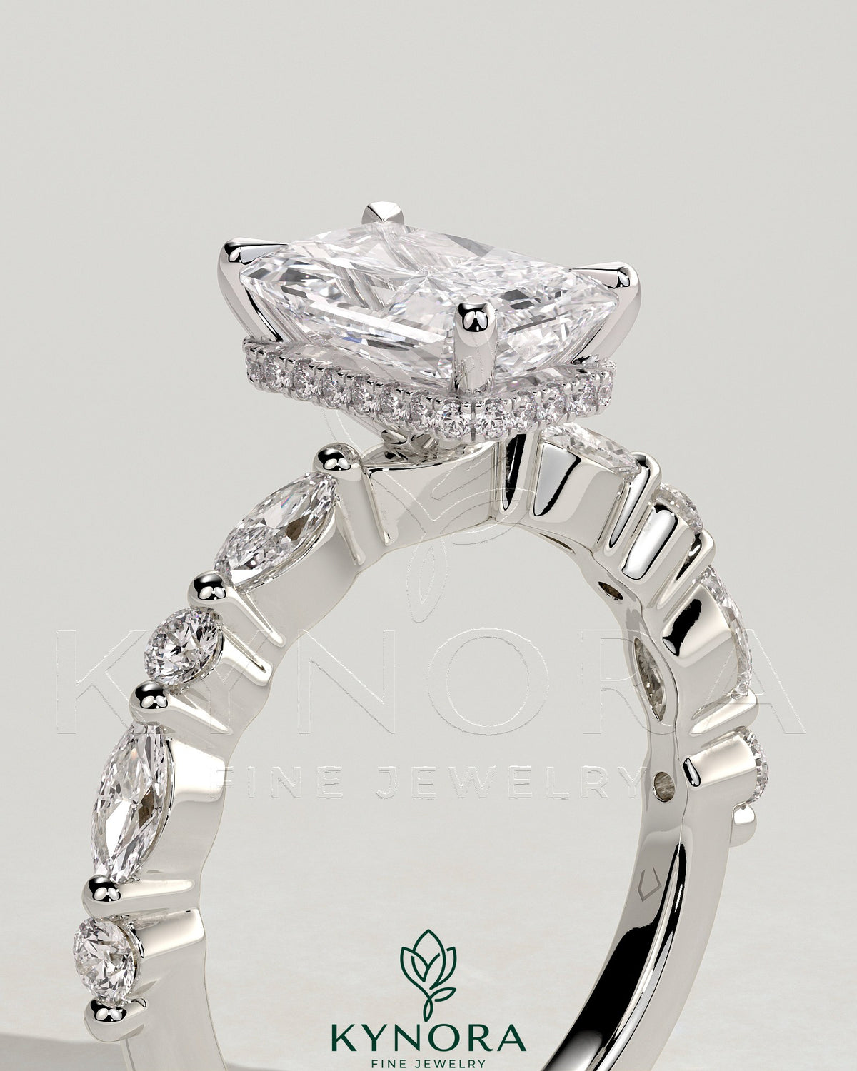 Kynora CJ 2ct radiant claw solitaire engagement ring with marquise and round accent stones, featuring a wrap-around hidden halo design.