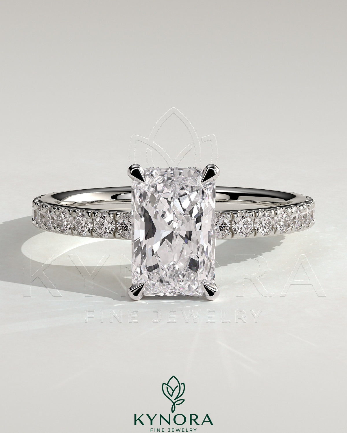 Kynora CJ 2ct radiant diamond claw solitaire engagement ring with wrap-around hidden halo and pave band details. Main image