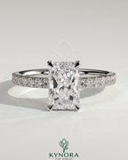 Kynora CJ 2ct radiant diamond claw solitaire engagement ring with wrap-around hidden halo and pave band details.
