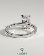Kynora CJ 2ct radiant claw solitaire engagement ring with wrap-around hidden halo and pave band, sparkling and elegant.