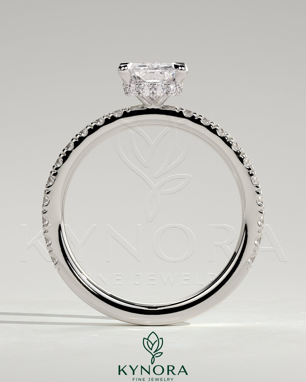 Kynora CJ 2ct radiant diamond claw solitaire engagement ring with wrap-around hidden halo and pave band design.