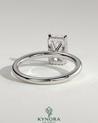 Kynora CJ 2ct radiant claw solitaire engagement ring with wrap-around hidden halo, featuring a sparkling central diamond.