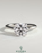 Kynora CJ 2ct round moissanite solitaire engagement ring with claw setting in sterling silver, stylish and elegant jewelry piece.