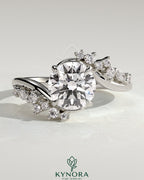 Kynora CJ 2ct round diamond solitaire engagement ring with bypass band and clustered marquise accent stones.