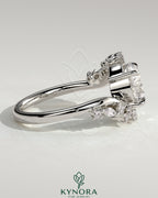 Kynora CJ 2ct round claw solitaire engagement ring with bypass band and clustered round-marquise accent stones.