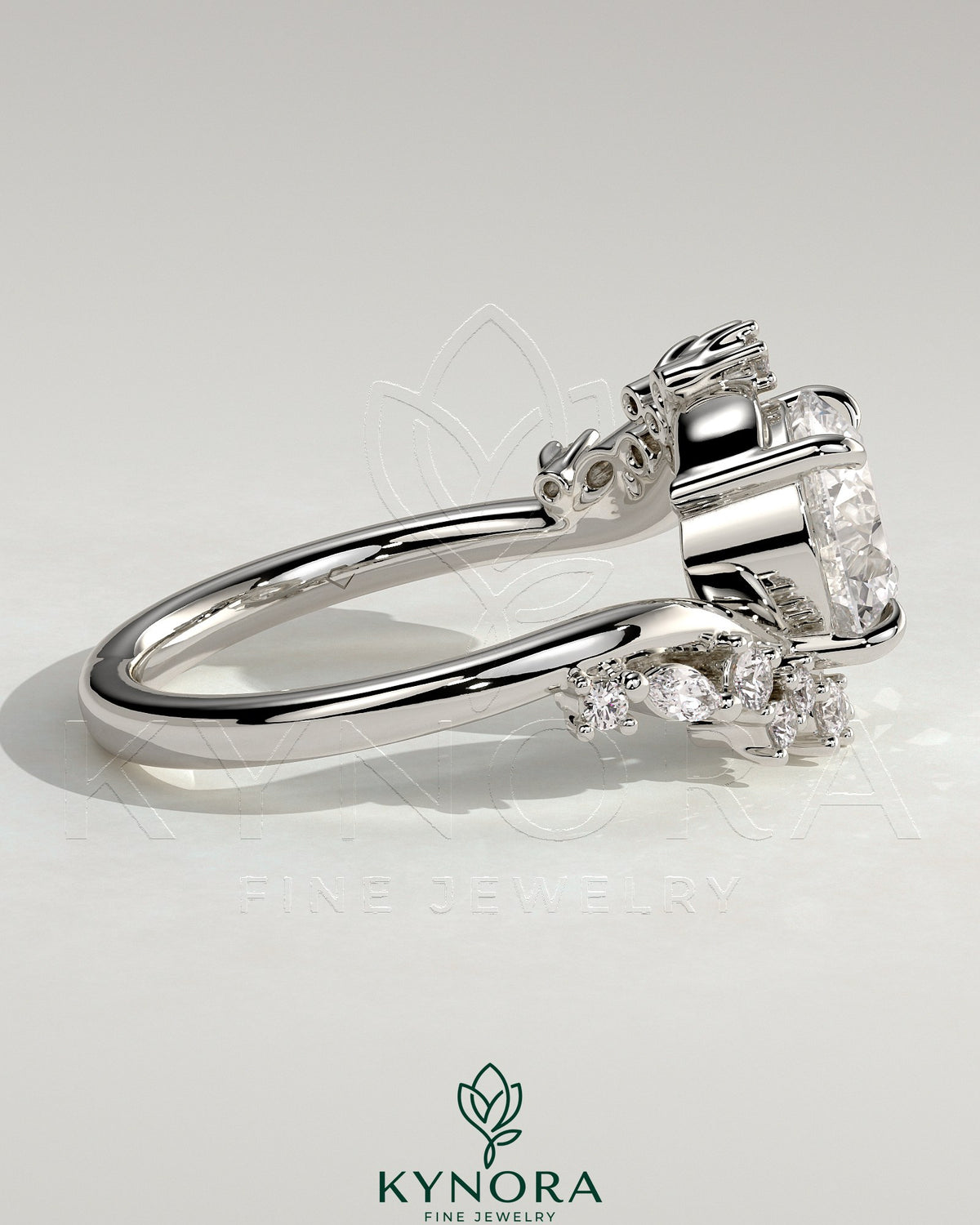 Kynora CJ 2ct round claw solitaire engagement ring with bypass band and clustered round-marquise accent stones.