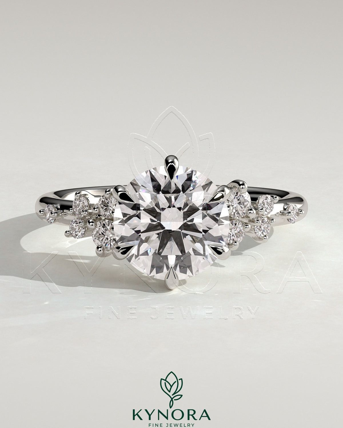 Kynora CJ 2ct round claw solitaire engagement ring with clustered round shoulder stones, showcasing a sparkling diamond design.