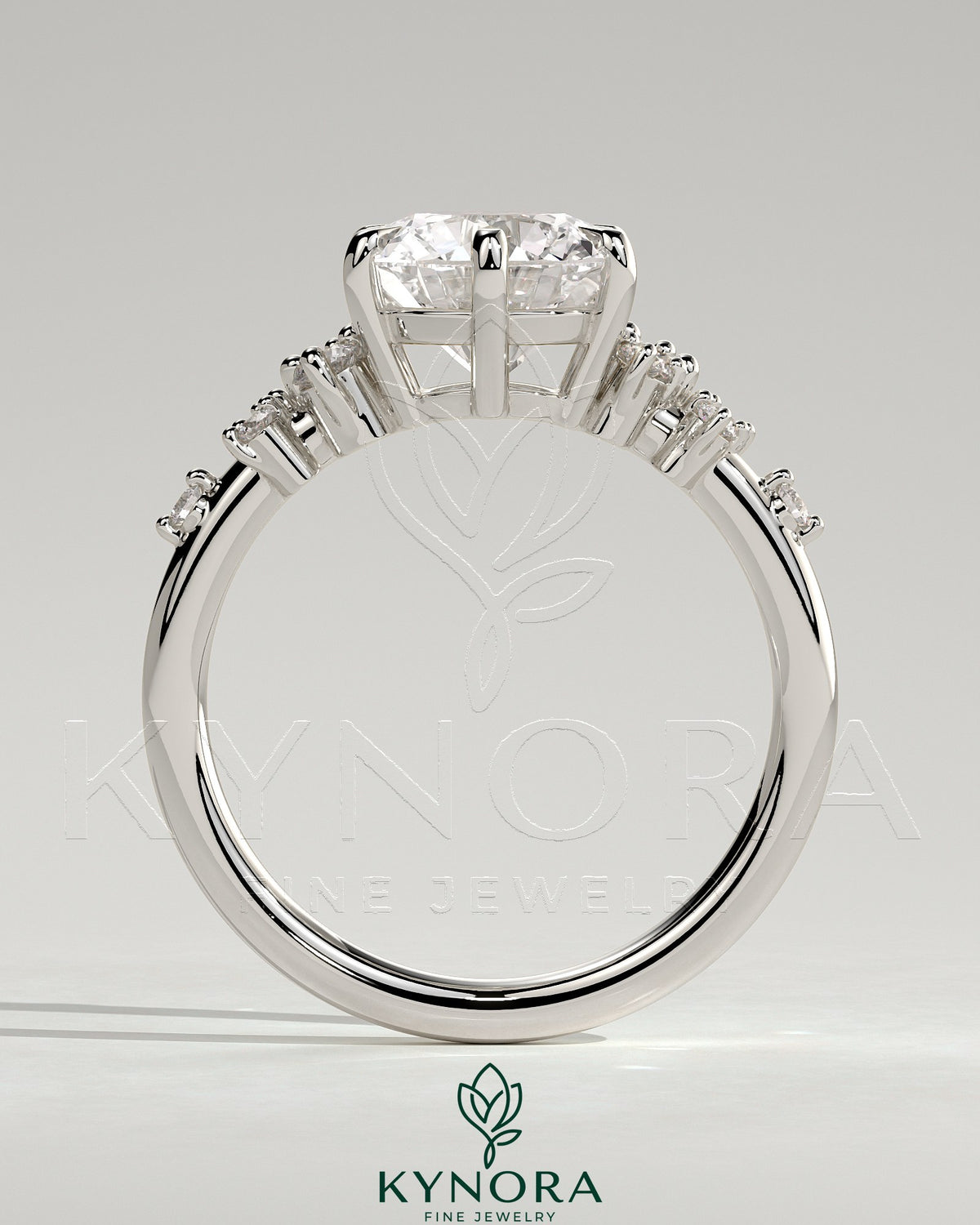 Kynora CJ 2-carat round claw solitaire engagement ring with clustered round shoulder stones, elegant and sparkling jewelry piece.
