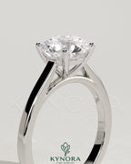 Kynora CJ 2ct round claw solitaire engagement ring with flat band and cathedral high setting, showcasing a sparkling diamond.