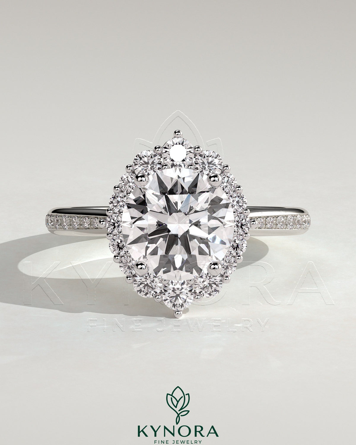 Kynora CJ 2ct round claw solitaire engagement ring with graduating halo, bead-set micropave accents, and tapered band. Main image