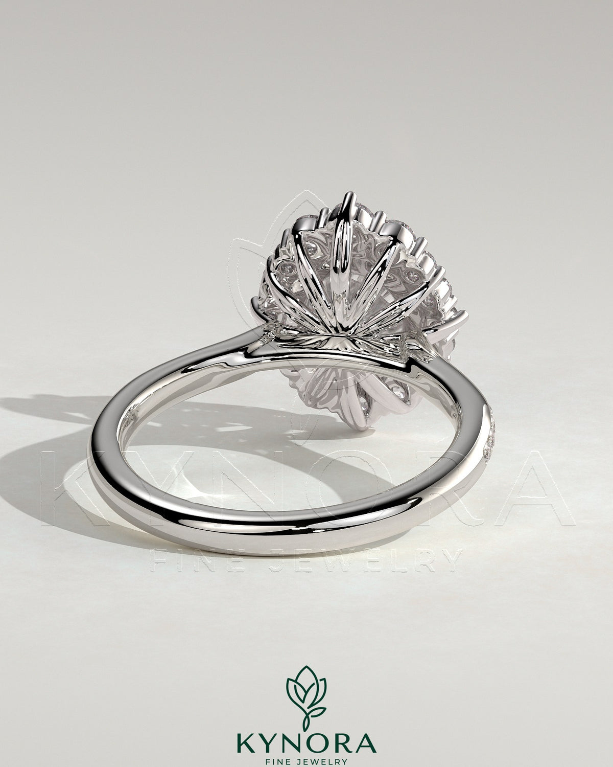 Kynora CJ 2ct round claw solitaire engagement ring with graduating halo, micropave bead set band, and tapered band design.