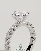 Kynora CJ 2ct round claw solitaire engagement ring with half eternity band, showcasing sparkling diamond setting and elegant design.