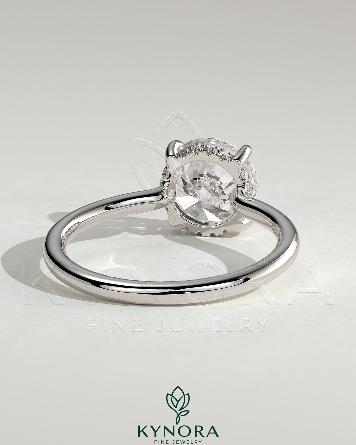 Kynora CJ 2ct round claw solitaire engagement ring with hidden halo and floating cathedral low setting, showcasing intricate metalwork.