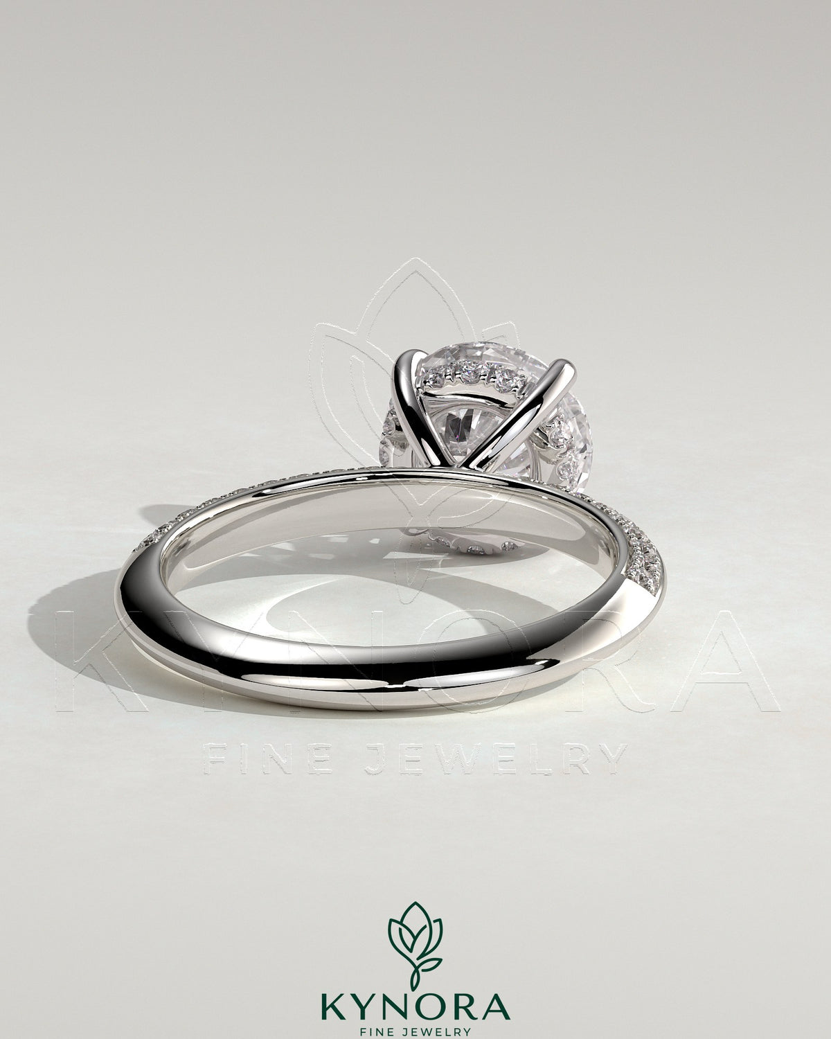 Kynora CJ 2ct round claw solitaire engagement ring with hidden halo and knife edge pave band, showcasing elegant jewelry craftsmanship.