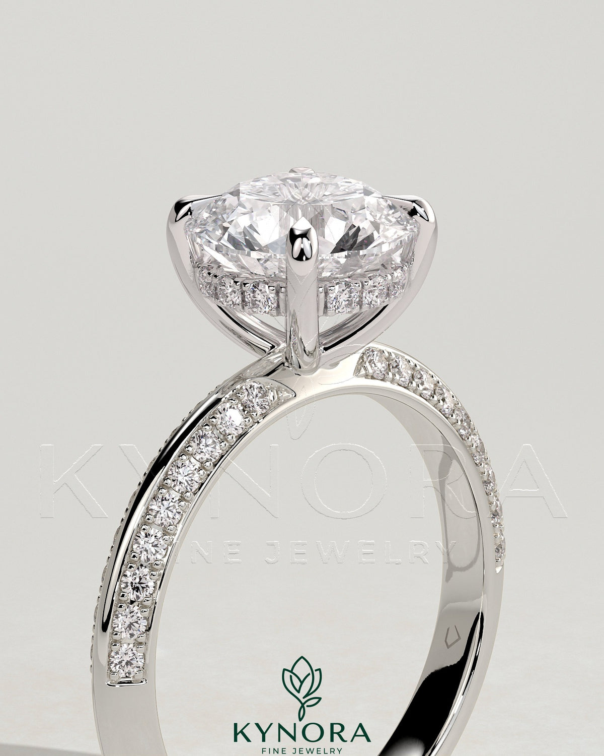 Kynora CJ 2ct round claw solitaire engagement ring with hidden halo and knife edge pave band, elegant and sparkling jewelry piece.