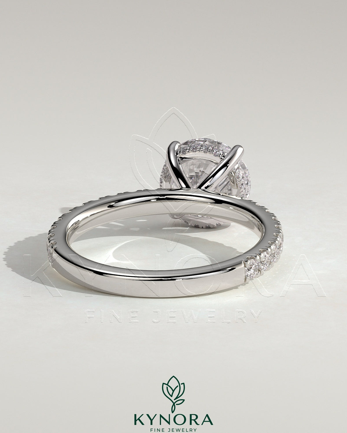 Kynora CJ 2ct round claw solitaire engagement ring with hidden halo and pave band, featuring sparkling diamond accents.