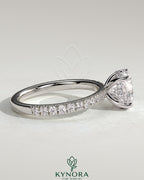 Kynora CJ 2ct round claw solitaire engagement ring with hidden halo and pave band, featuring sparkling diamond details.