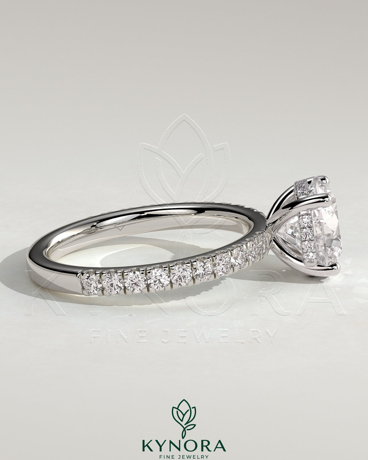Kynora CJ 2ct round claw solitaire engagement ring with hidden halo and pave band, featuring sparkling diamond details.