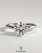 Kynora CJ 2-carat round claw solitaire engagement ring with hidden halo, showcasing sparkling diamond and elegant design.