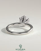 Kynora CJ 2ct round claw solitaire engagement ring with hidden halo and sparkling diamond accents on a sleek band.
